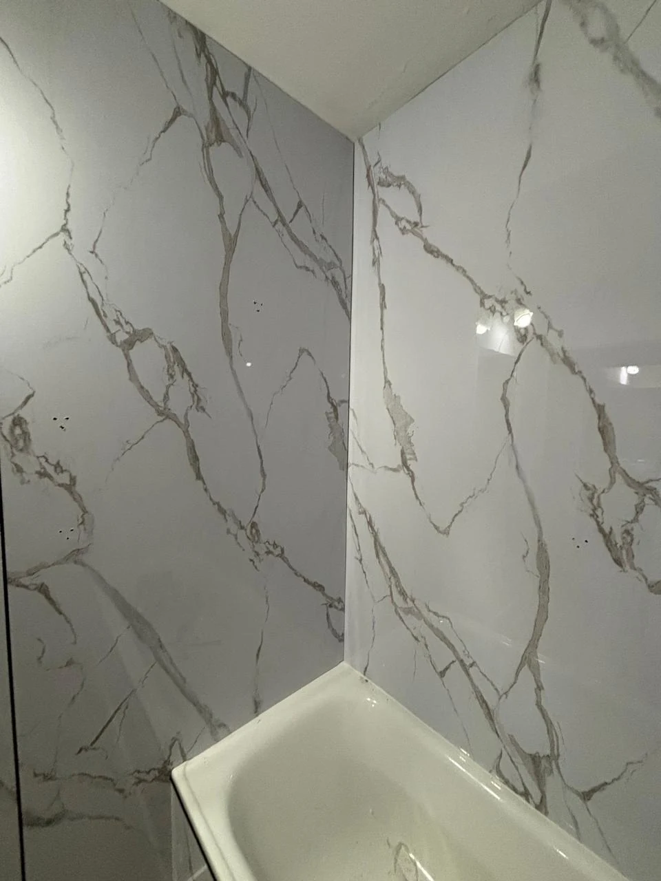 Detalle de la pared de la bañera en Calacatta blanco